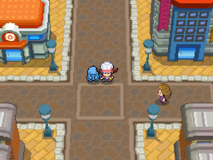 The player on the street between the Pokémon Center (left) and the Goldenrod Department Store (right) / Pokemon HGSS