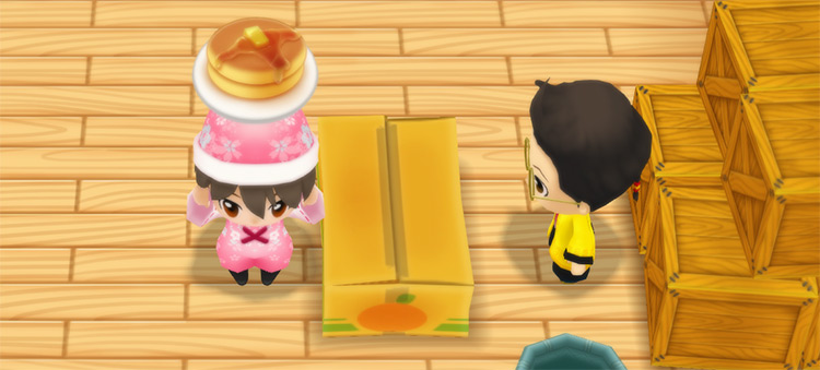 The farmer stands in front of Huang’s counter while holding a stack of Pancakes. / Story of Seasons: Friends of Mineral Town