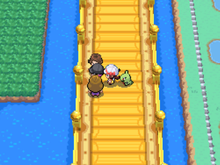 The Team Rocket Grunt attempting to hide between the couple on Route 24’s golden bridge / Pokémon HGSS