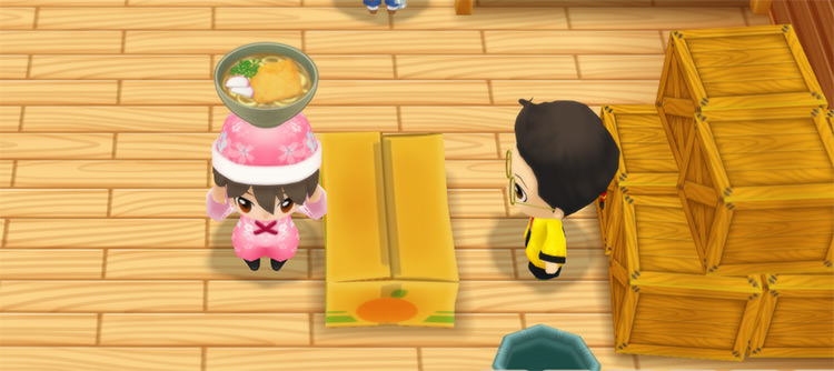 The farmer stands in front of Huang’s counter while holding a bowl of Ramen. / Story of Seasons: Friends of Mineral Town